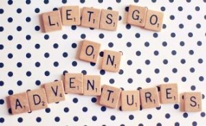 words on squares spelling out "Lets go on adventures" on a white background with blue dots